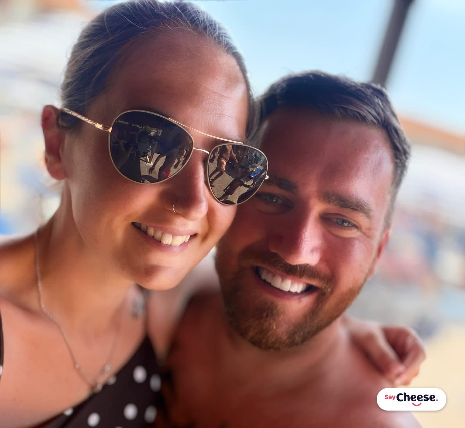 A couple grinning into a sunny selfie